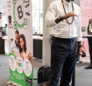 A CashBlack presenter at a pop-up marketplace, beside a CashBlack banner